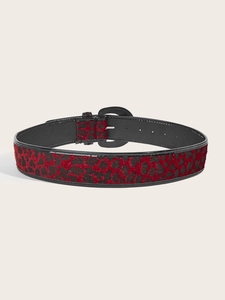Close-up of a red leopard print belt with a matte black round buckle and textured finish