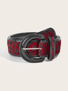 Close-up of red and black leopard print belt with high-gloss black buckle and faux horsehair texture