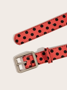 Close-up of red leather belt with black polka dots and silver square metal buckle