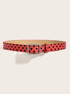 Detail of red belt with black polka dots and matte silver square buckle on a pedestal