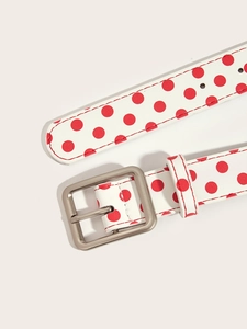 Detail of white and red polka dot slim belt with silver square buckle and fine stitching