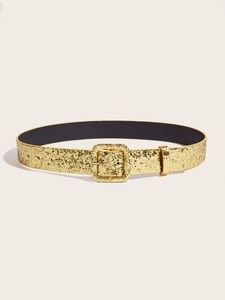 Macro shot of gold glitter texture on women belt with matching rectangular buckle detail