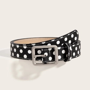 Macro detail of vintage Y2K black belt with white polka dots and silver buckle