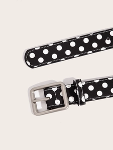 Detailed macro view of black belt with white polka dots and silver metal buckle