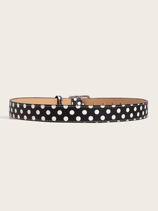 Detailed view of black and white polka dot belt with a silver square pin buckle