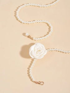 Detail view of pearl chain with camellia flower and gold clasp for dresses