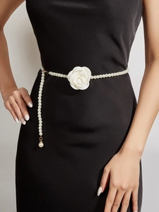 Detail of beaded pearl waist chain with white fabric rose flower for dresses