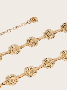 Detailansicht der goldenen Metall-Taillenkette mit geprägten Rosenblüten-Gliedern