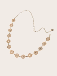 Detail of bohemian gold metal waist chain with embossed round plates and lobster clasp