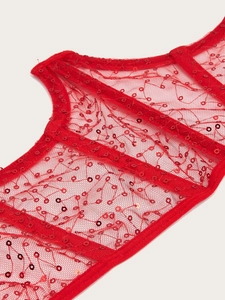 Detail of red sequined lace corset with vertical boning and sheer mesh fabric