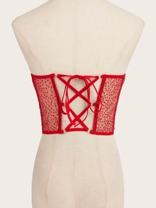 Detail view of red sequin corset waist belt with criss-cross lace-up back design