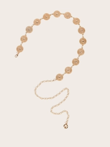 Detailed macro view of Bohemian golden metal waist chain with embossed medallions