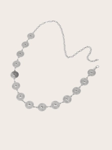 Detail of bohemian silver metal waist chain with embossed circular relief patterns