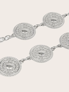 Macro shot of silver vintage chain belt with embossed sunburst texture metal discs