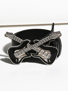 Dettaglio di una cintura in stile rock con fibbia metallica a forma di doppie chitarre