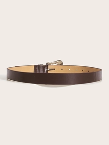 Macro-opname van donkerbruine leren riem met studs en een zilveren ovale metalen gesp