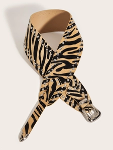 Detailed view of punk zebra print leather belt with silver studs and engraved western buckle