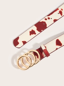 Dettaglio della cintura in pelle con motivo mucca bianco e rosso e fibbia dorata a tre anelli