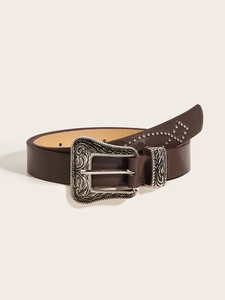 Detail van de zilveren western gesp met bloemmotief en klinknagels op bruin leder