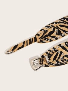 Detail of bohemian zebra print belt with silver studs and vintage metal buckle