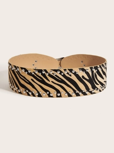 Detailed macro view of zebra print belt featuring dual rows of silver metal rivets