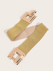 Détail d'une large ceinture élastique dorée avec boucle carrée pour manteaux et vestes