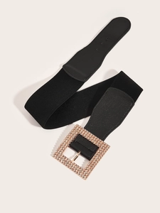 Detail of wide elastic waist belt featuring a luxury gold buckle with sparkling rhinestones