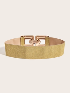 Détail de la large ceinture élastique dorée avec boucle géométrique en métal or rose