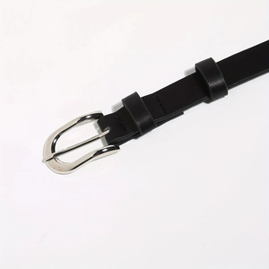 Detailed close-up of a black punk rivet belt with a silver horseshoe buckle and leather texture