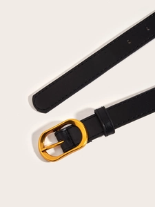 Detail of a thin black leather belt featuring a polished gold oval metal buckle with stitching