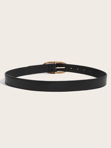 Détail d'une ceinture noire fine avec boucle ovale dorée et coutures sur similicuir souple