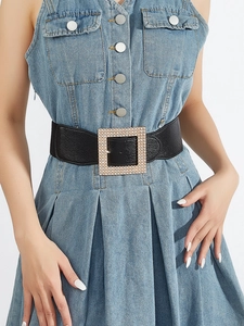 Detail of a wide black elastic belt for women with a luxury rhinestone square buckle