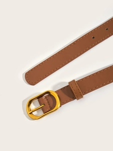 Detail of brown leather belt showing golden oval buckle and fine stitching craftsmanship