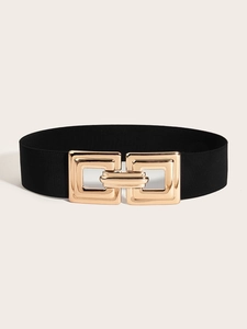 Détail d'une large ceinture élastique avec une boucle géométrique dorée entrelacée
