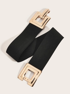 Gros plan sur une large ceinture élastique noire avec une boucle carrée dorée et polie