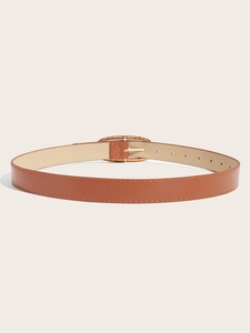 Détail d'une ceinture en cuir marron vintage avec boucle ovale dorée et trous de réglage fins