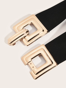 Détail d'une large ceinture élastique vintage avec boucle métallique carrée dorée