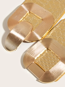 Close-up of golden buckle with brushed texture and embossed snake pattern faux leather strap