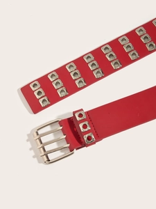 Detail of red punk leather belt with triple-row silver eyelets and three-pin metal buckle