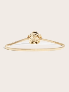 Detail of golden camellia flower metal buckle with elastic woven belt texture