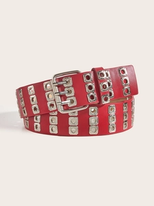 Detail of red punk belt with double-row metal eyelets and silver buckle on white background