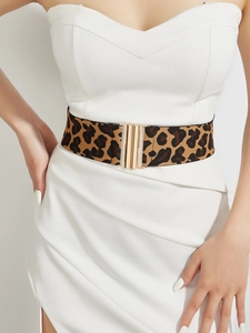 Detail of leopard print wide elastic belt with gold metal buckle on white clothes