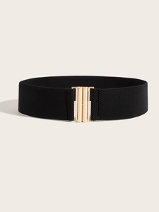 Detail of a wide elastic black corset belt with a polished gold rectangular metal buckle