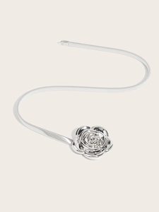 Detail of silver elastic metal belt with a polished 3D rose flower buckle on white background