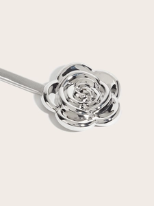 Macro shot of polished silver rose buckle on an elastic metal spring belt for dresses