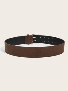 Detail of wide dark brown suede belt featuring a vintage silver double-prong buckle