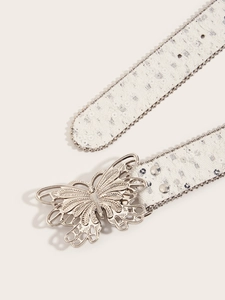 Détail de ceinture en toile avec sequins et boucle papillon argentée sur fond beige