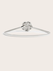 Detail of silver metallic spring belt featuring a polished rose shaped buckle for dresses
