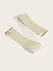 Detail view of champagne gold elastic waist belt with sleek golden metal buckle fastener