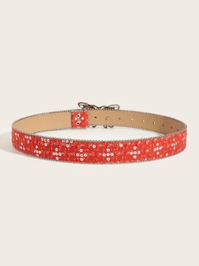 Détail de la ceinture en toile rouge avec clous en étoile et bordure de perles argentées